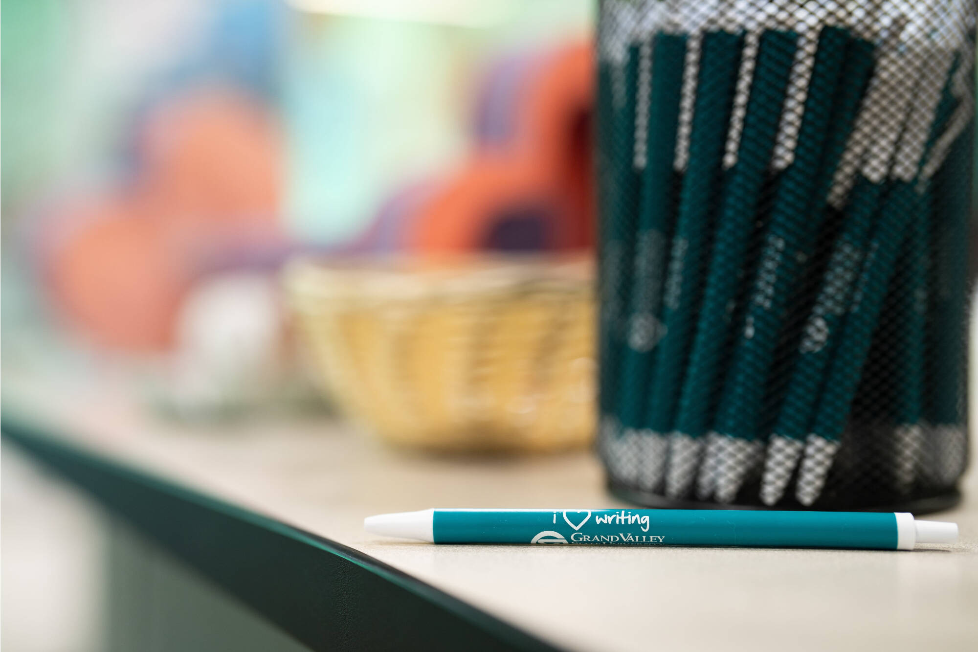 Close up look of a teal GVSU writing center pen